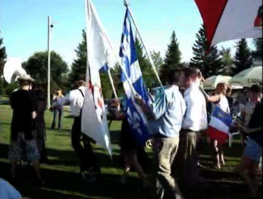 Écoliers posant fièrement devant un drapeau acadien géant